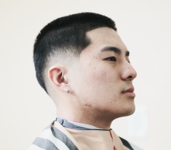 An Asian man with a fade haircut looking to the right