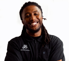 Barber with black shirt smiling